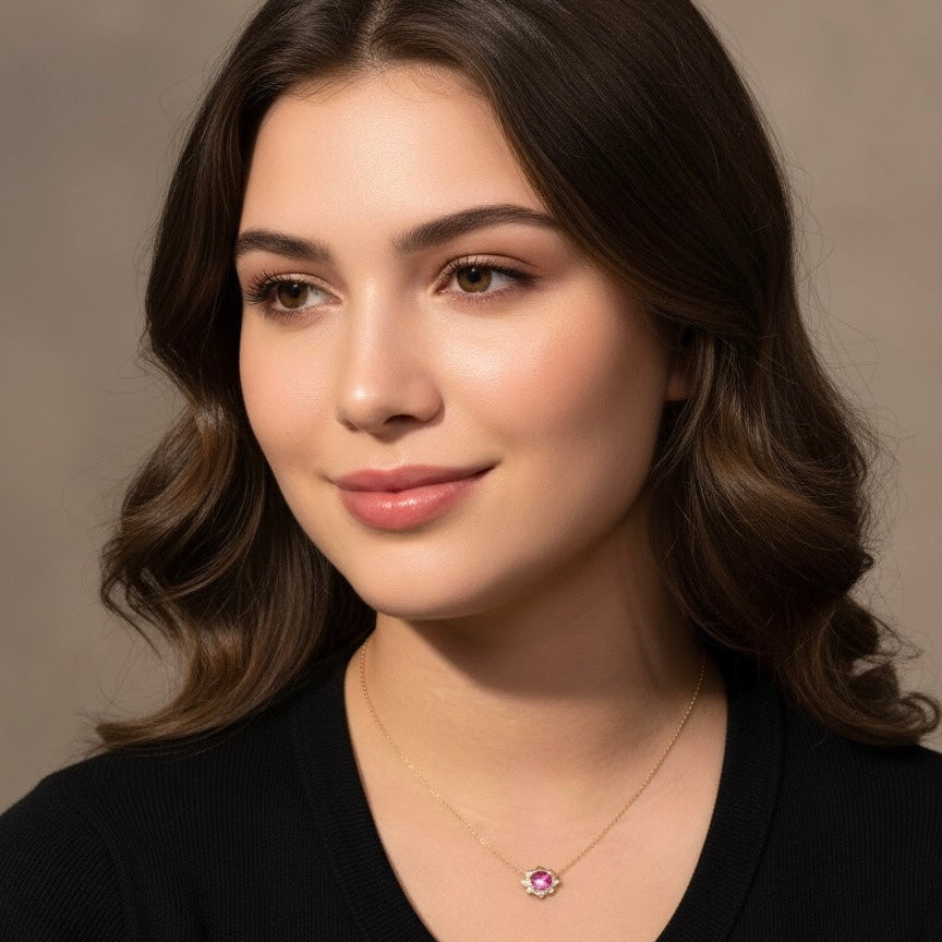 Woman wearing a necklace with a pink gemstone against a neutral background